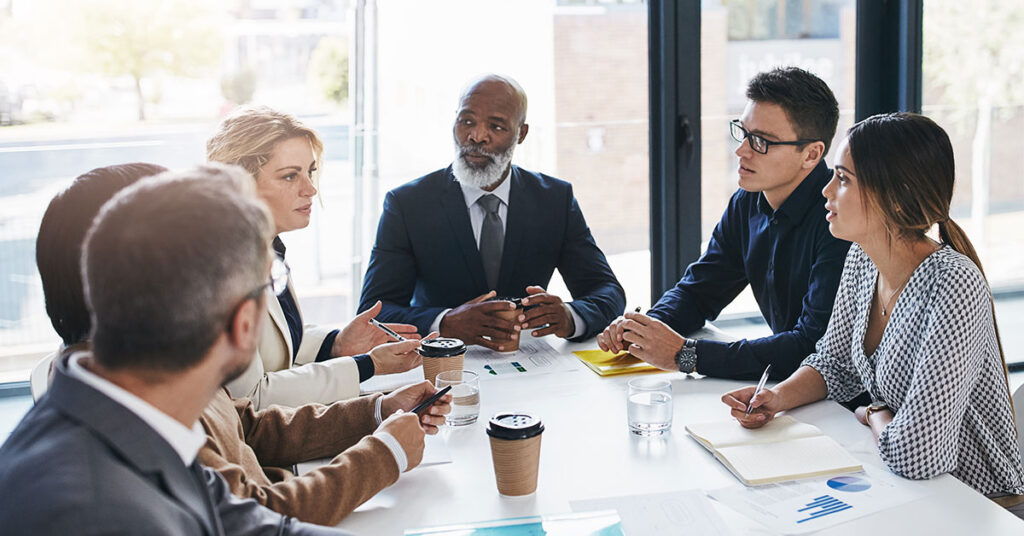 Six business professionals meeting around a conference table