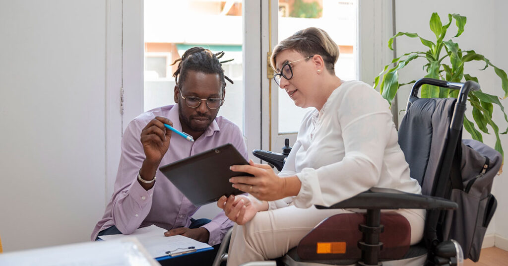 woman in wheelchair working with male colleague